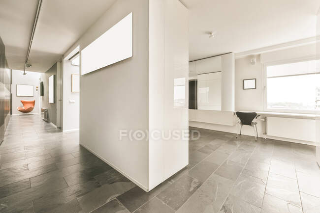 Мінімалістський стиль інтер'єру сучасного просторного залу з білими стінами і мармуровою підлогою прикрашені кріслами і прикрашені пустими макетами. — стокове фото