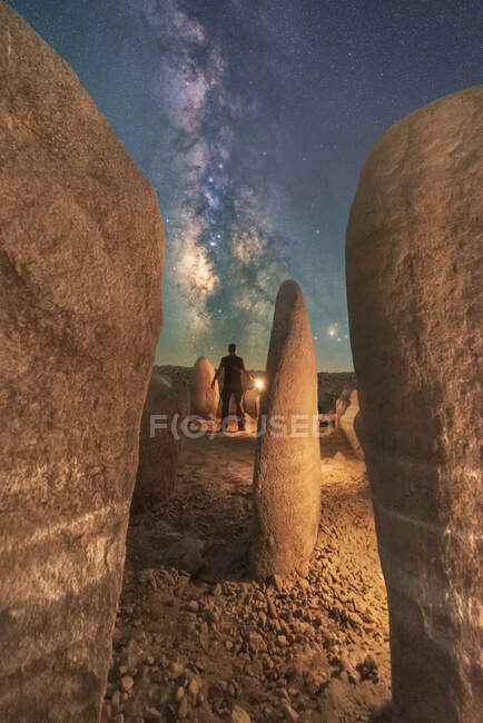 Visão traseira do turista anônimo masculino admirando Guadalperal Dolmen sob céu estrelado com galáxia em Cáceres Espanha — Fotografia de Stock