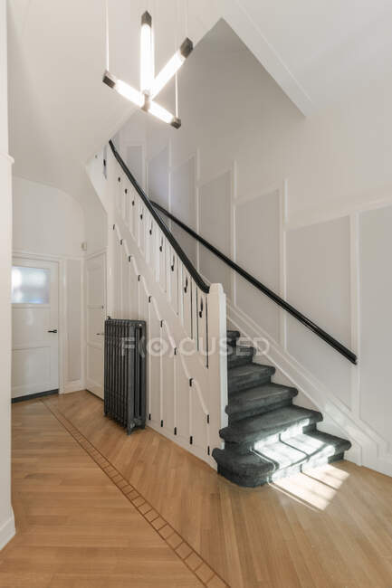 Інтер'єр просторого коридору зі сходами на сучасному будинку, спроектований в мінімальному стилі — стокове фото