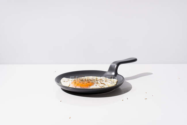 Köstliches Spiegelei auf schwarzer Pfanne serviert auf Tisch auf weißem Hintergrund im Studio — Stockfoto