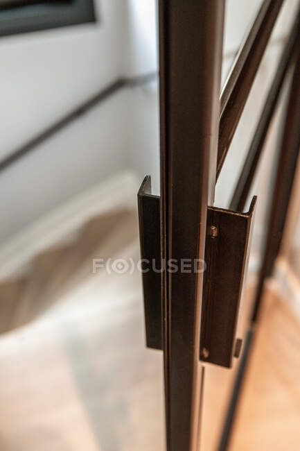 De cima do punho da porta de metal da porta de vidro moderna que conduz à escada na casa no estilo mínimo — Fotografia de Stock