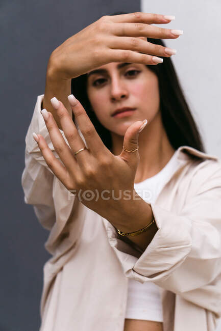 Tranquil graceful woman reaching out hands towards camera while dancing in city street — Stock Photo