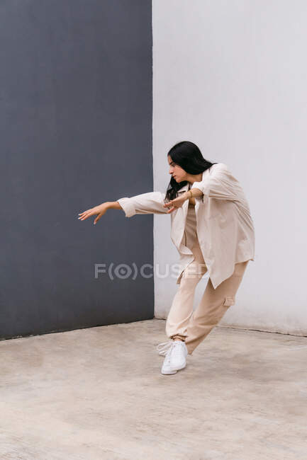 Talented female dancer moving and dancing near concrete wall in urban area in city — Stock Photo