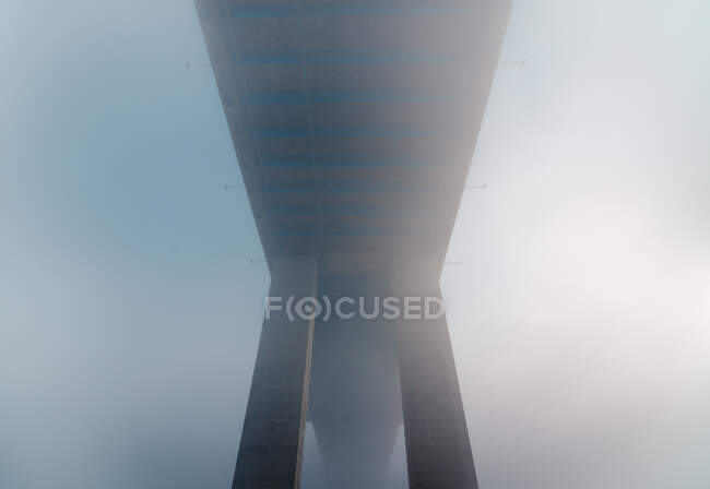 From below contemporary concrete bridge located in thick fog early in morning in Lisbon, Portugal — Stock Photo