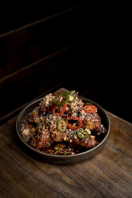 Hohe Winkel von leckeren gegrillten Chicken Wings mit BBQ-Sauce und würzigen Paprika auf dem Tisch im Restaurant platziert — Stockfoto