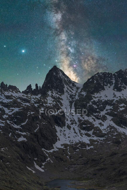 Spectacular view of galaxy in sky with interstellar gas over rough majestic mount with snow in evening — Stock Photo