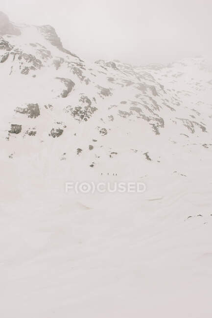 Athlètes anonymes à ski sur Pico Aunamendi dans les Pyrénées enneigées Montagnes sous un ciel nuageux en Navarre Espagne — Photo de stock