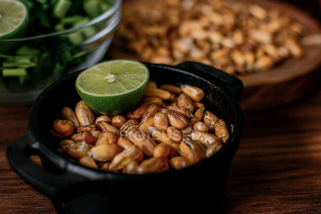 Pilha de grãos de cereais em tigela colocada sobre mesa de madeira na cozinha — Fotografia de Stock