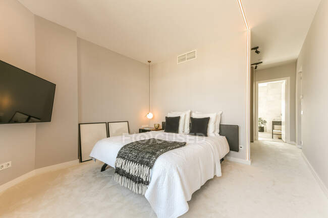 Intérieur de la chambre avec lit doux avec oreillers et TV moderne — Photo de stock