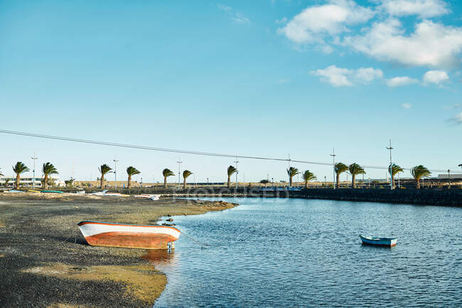 Navi Shabby situate sulla costa squallida e l'acqua del fiume increspatura in giornata ventosa a Fuerteventura, Spagna — Foto stock