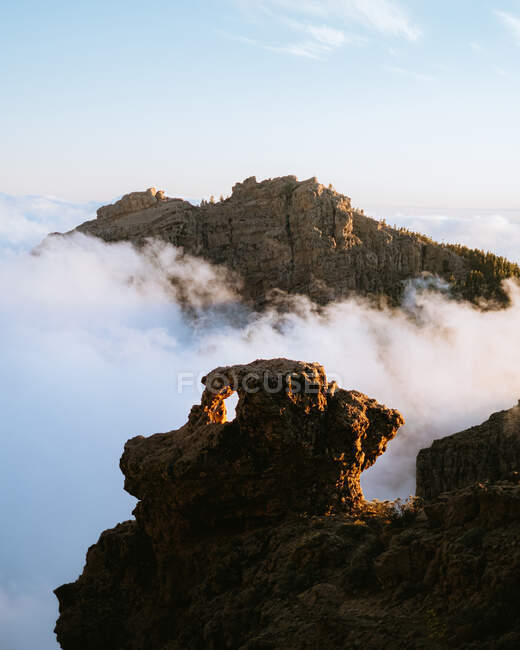 Spektakuläre Landschaft aus felsigem Gelände im Hochland, umgeben von dicken Wolken im Sonnenuntergang — Stockfoto