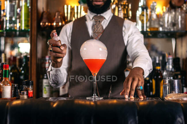 Ritagliato irriconoscibile alla moda afroamericano barista maschile che fuma bevande alcoliche al lavoro nel pub — Foto stock