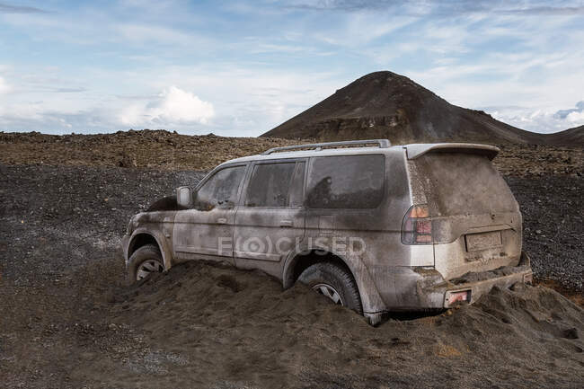 Véhicule tout terrain couvert de saleté et de sable volcanique après éruption contre Fagradalsfjall en journée en Islande — Photo de stock