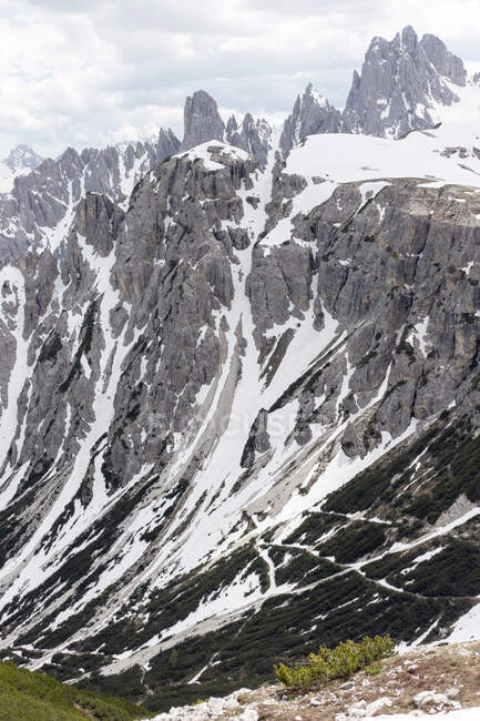 Paysage spectaculaire d'une pente rocheuse rugueuse recouverte de neige dans les Dolomites en Italie — Photo de stock