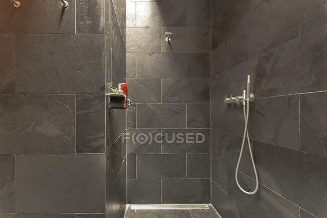 Interior do banheiro moderno com paredes cinza e piso projetado em estilo mínimo — Fotografia de Stock