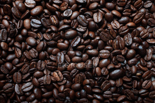 Blick über den Hintergrund, der die Hälften dunkelbrauner Kaffeebohnen mit angenehmem Duft darstellt — Stockfoto