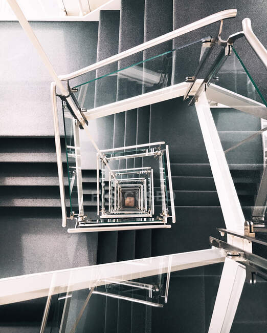 From above of creative spiral stairway with concrete steps and glass banister in contemporary building in Hamburg — Stock Photo