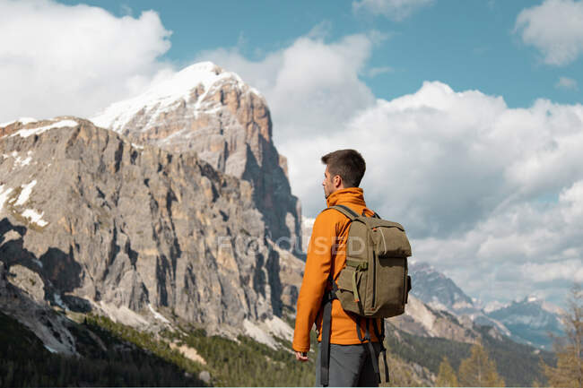 Vista posteriore dell'uomo viaggiatore anonimo con zaino in piedi durante il trekking sulle Dolomiti — Foto stock