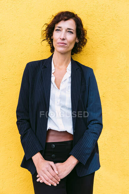 Self assured elegant female wearing formal outfit standing looking away — Stock Photo