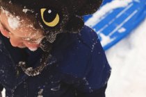 Смішний усміхнений хлопчик зі снігом на обличчі — стокове фото