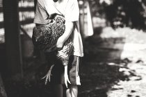 Kleiner Junge hält Henne — Stockfoto
