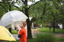Mignon petit garçon souriant avec parapluie — Photo de stock