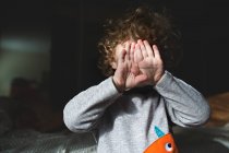 Adorable niño escondiendo la cara - foto de stock