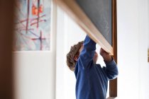 Kleiner Junge schreibt auf Tafel — Stockfoto