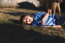 Улыбающийся мальчик на траве — стоковое фото