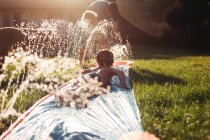 Little brothers playing with watering system — Stock Photo