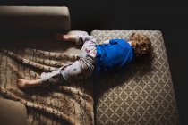Мальчик в пижаме спит на диване — стоковое фото