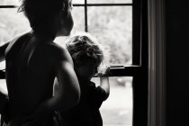 Маленькі брати стоять біля вікна — стокове фото
