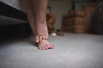Pies de niño de pie sobre la alfombra - foto de stock