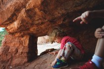 Little boys playing in rocky cave — Stock Photo