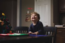 Petit garçon assis riant — Photo de stock