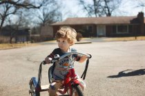 Маленький хлопчик їде на велосипеді по дорозі — стокове фото