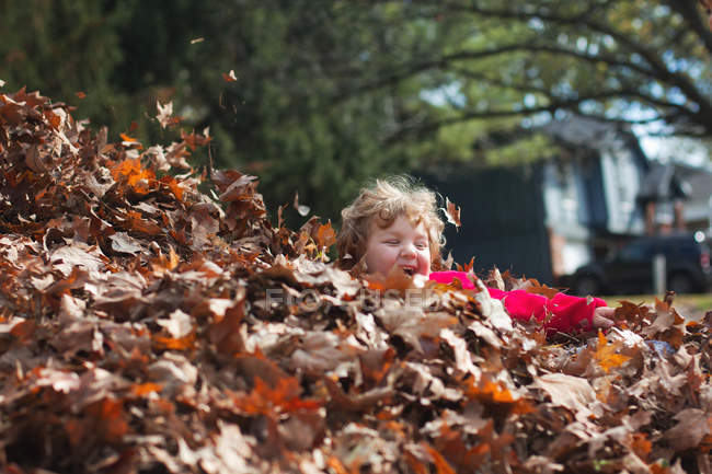 Pequeño niño jugando en otoño hojas - foto de stock