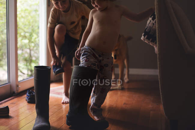 Irmãos felizes brincando com botas de borracha — Fotografia de Stock