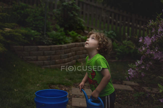 Маленький мальчик держит лейку — стоковое фото