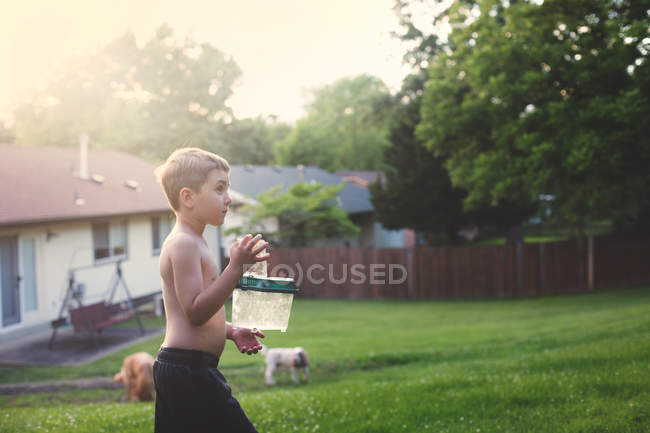 Маленький хлопчик тримає коробку на задньому дворі — стокове фото