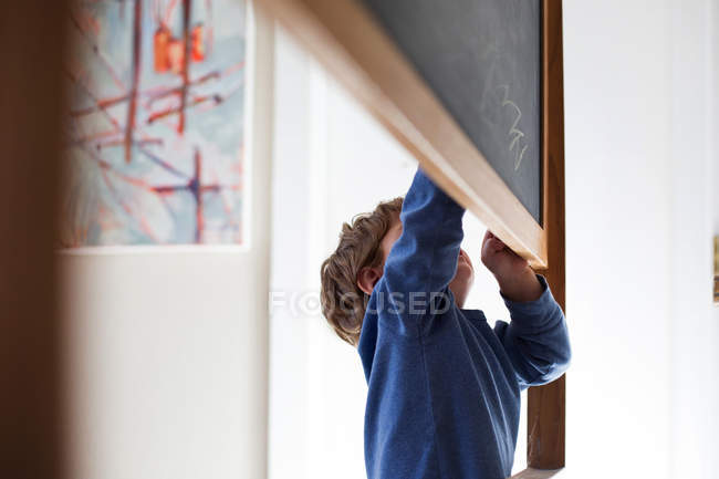 Menino escrevendo no quadro negro — Fotografia de Stock