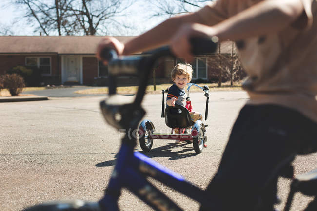 Маленькі брати на велосипеді їздять по дорозі — стокове фото