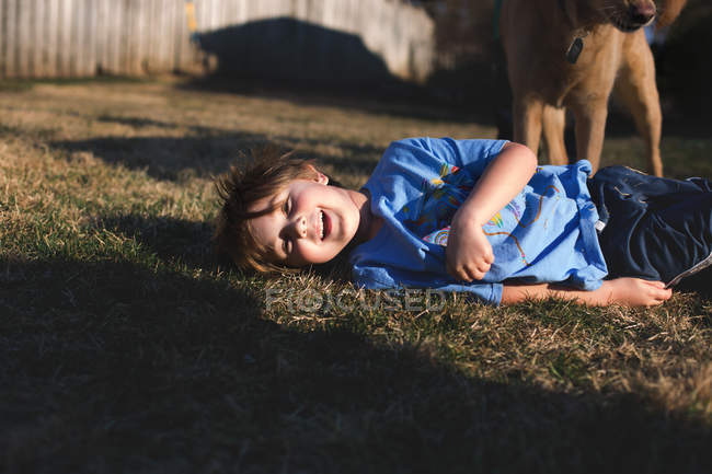 Усміхнений маленький хлопчик на траві — стокове фото