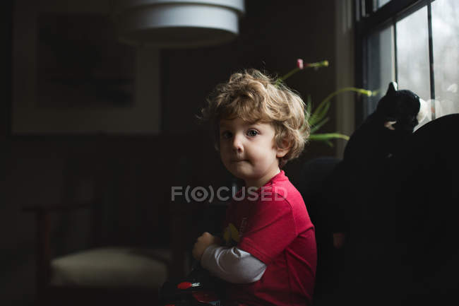 Очаровательный маленький мальчик сидит на диване — стоковое фото