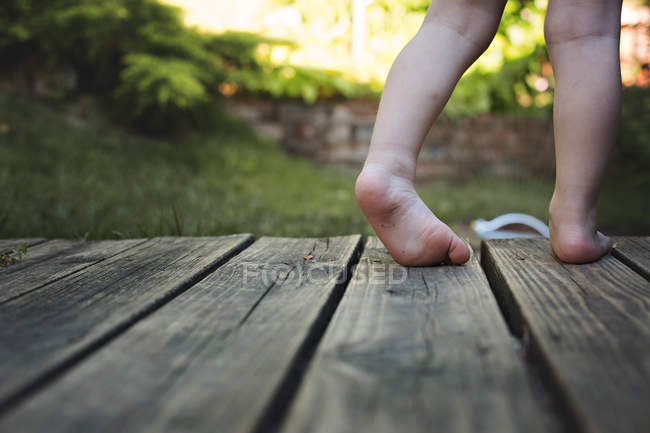 Piedi di bambino sul pavimento in legno — Foto stock
