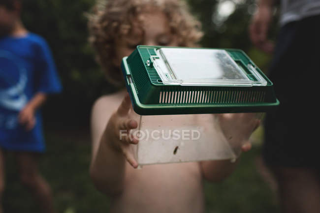 Petit garçon tenant boîte avec insecte — Photo de stock
