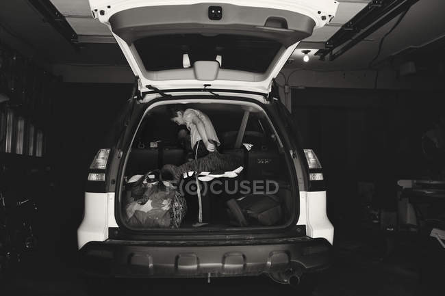 Petit garçon chargeant des sacs dans la voiture — Photo de stock