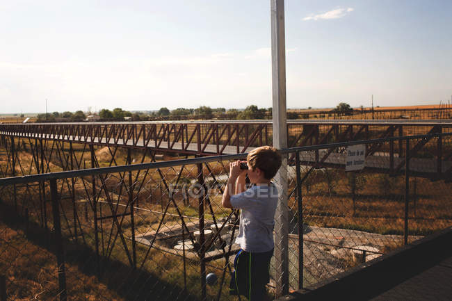 Little boy looking in binoculars — Stock Photo