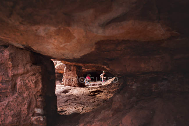 Little boys playing in rocky cave — Stock Photo