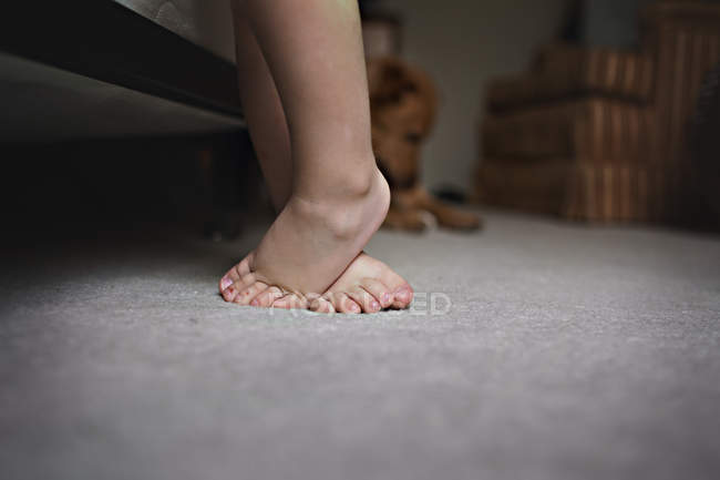 Ноги маленького хлопчика, що стоїть на килимі — стокове фото